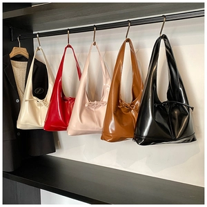 Detail view of glossy tote bags with drawstring bows in five vibrant colors hanging on a rack