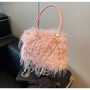 Detail of pink feather bucket bag featuring a round handle, large pearls and gold chain