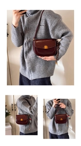 Détail du sac selle bordeaux avec rabat texture croco et fermoir métallique doré