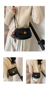 Détail du sac selle noir en similicuir avec texture crocodile et fermoir doré chic