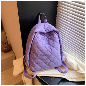 Gros plan du sac à dos matelassé violet avec motif en losange et fermeture éclair