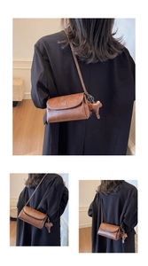 Détail d'un sac bandoulière vintage en cuir marron avec logo en métal et breloque ours