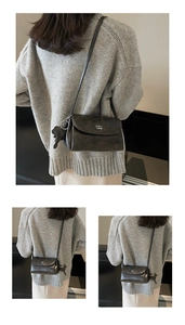 Vue détaillée du petit sac carré rétro marron avec pendentif chien et logo élégant
