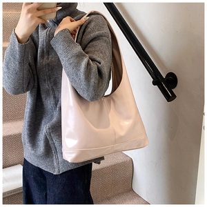 Detail of elegant beige patent leather shoulder bag with vertical stitching and glossy finish