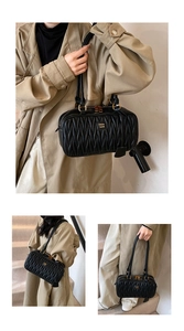 Black ruched shoulder pillow bag for women, stylish quilted handbag with gold hardware.