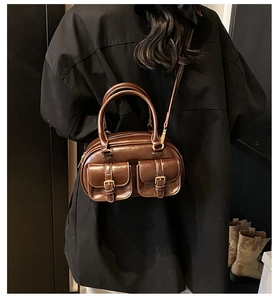 Detail of vintage dark brown bowling bag with double pockets and glossy oil-wax leather