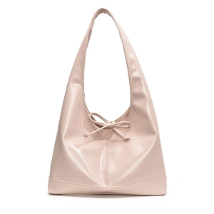 Detailed view of pale pink hobo bag featuring glossy patent leather and a bow drawstring