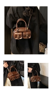 Close-up of vintage brown leather Boston bag featuring decorative front pockets