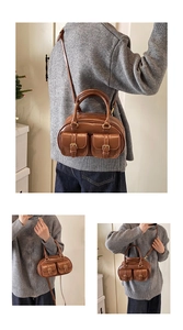 Detail of vintage brown bowling bag featuring front metal buckle pockets and long strap