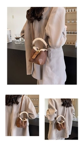 Detail of a brown faux suede mini bucket bag with soft white faux fur trim and gold hardware