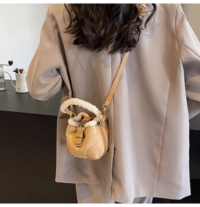 Mini plush bucket bag in brown faux fur with a crossbody strap on an autumn outfit