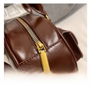 Detail of premium dark brown leather texture with high-quality gold metal zipper