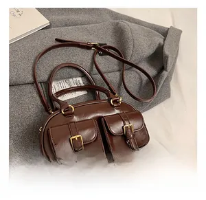 Detail showing dual cargo buckle pockets and gold hardware on brown vintage bowling bag