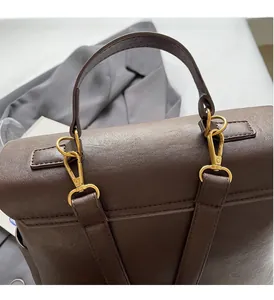 Macro detail of brown lychee leather texture and premium gold metal hardware hooks