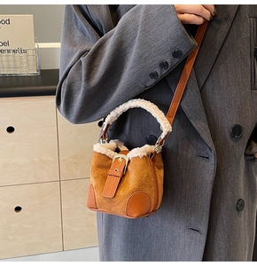 Close-up of mini bucket bag with brown suede and white faux fur trim detail