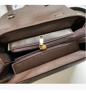 Detail of smooth gold zipper and stitching on a dark brown vintage leather shoulder bag