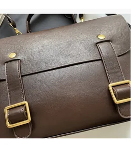 Detailed macro view of dark brown pebbled leather texture and matte gold buckles