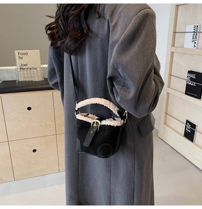 Detail of mini bucket bag with black suede and cream shearling trim for autumn