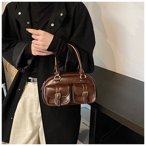 Detail of dark brown retro bowling bag with gold hardware and two front pockets