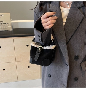 Detail of a vintage mini bucket bag with fuzzy shearling trim and decorative leather strap