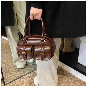 Detailed shot of retro brown leather handbag with metallic buckle pockets and handles