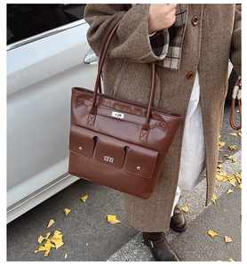 Détail du cabas marron vintage avec deux poches avant et fermoirs rotatifs en métal argent