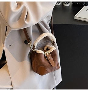 Close-up of brown suede mini bucket bag with white faux fur trim and gold metal hardware