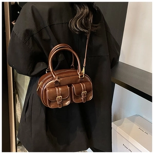 Detail of vintage brown leather bowling bag showing double front pockets and gold hardware