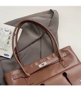 Vue détaillée d'un sac cabas marron foncé avec fermoir tournant en métal et longues bandoulières
