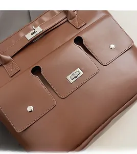 Gros plan du sac cabas en cuir marron montrant le fermoir en métal argenté et la texture