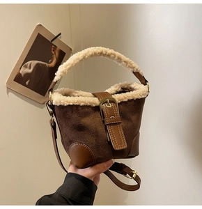 Detail of retro suede bucket bag featuring plush faux fur trim and metal buckle accent