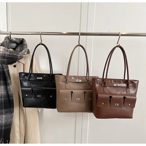 Trois grands sacs cabas en noir, taupe et café avec des fermoirs rotatifs en métal