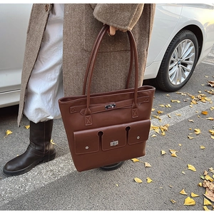 Gros plan du sac cabas en cuir marron foncé avec fermoir en métal au décor automnal