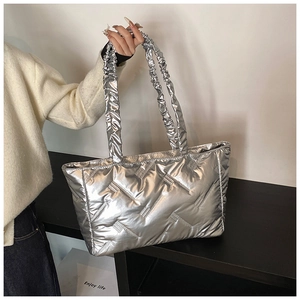Detail of silver quilted puffer tote bag featuring unique gathered elastic shoulder strap