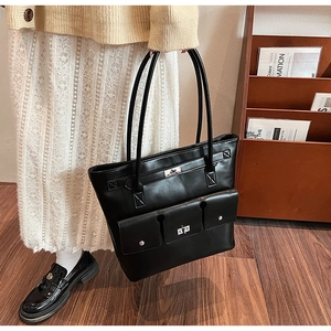 Détail du grand sac cabas noir en PU avec fermoir rotatif porté par un mannequin