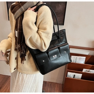 Gros plan d'un grand sac cabas en cuir noir mat avec un fermoir rotatif en métal