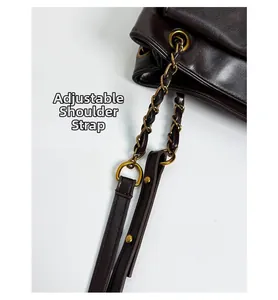 Detail of adjustable stitched shoulder strap with vintage bronze chain and leather