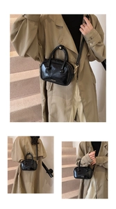 Dettaglio della piccola borsa a mano in pelle nera lucida con logo del marchio in metallo