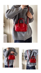 Dettaglio della borsa in pelle verniciata rossa lucida con manico sferico e logo