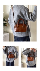 Dettaglio borsa in pelle lucida marrone con finiture dorate e sfere decorative