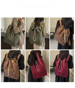 Detail view of leopard print drawstring backpacks in green, khaki, and burgundy options