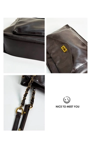 Close-up of dark brown textured leather tote with gold twist lock and woven chain strap