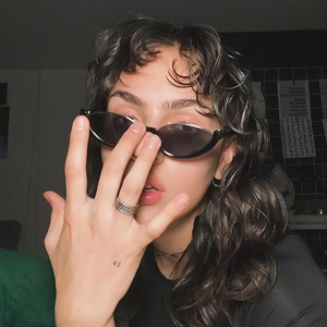 Fashionable black cat-eye sunglasses and vintage silver braided ring on a model