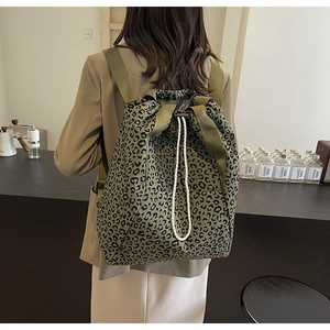 Detail of dark green leopard print drawstring backpack with woven straps and ropes