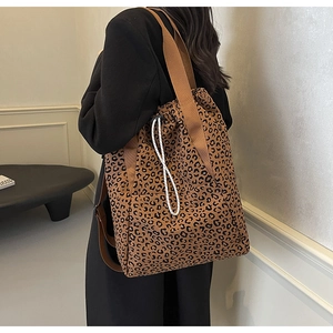 Detail of stylish leopard print tote bag with drawstring closure and durable canvas texture