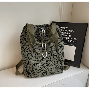 Detail of army green leopard print tote bag with white drawstring closure and woven handles
