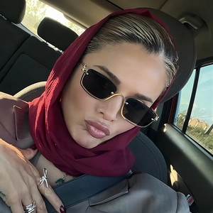 Detail of square semi-rimless sunglasses with gold metal temples and burgundy chiffon hijab