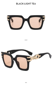 Detail of square black frame sunglasses featuring gold chain temples and light tea lenses