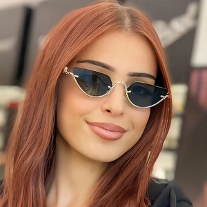 Silver thin metal cat eye sunglasses with dark grey lenses on a female model