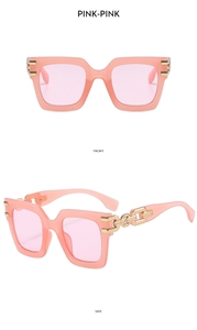 Close-up of pink square sunglasses featuring stylish golden metal chain temples